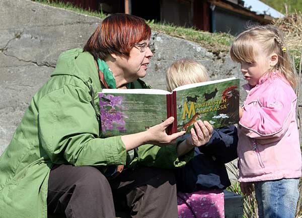 Kirsti ja lapset lukevat kirjaa